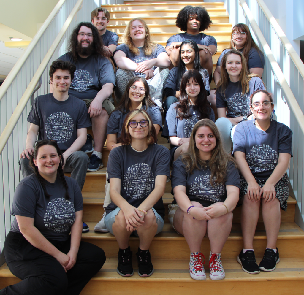 Group of 14 students on The Commons steps wearing matching shirts